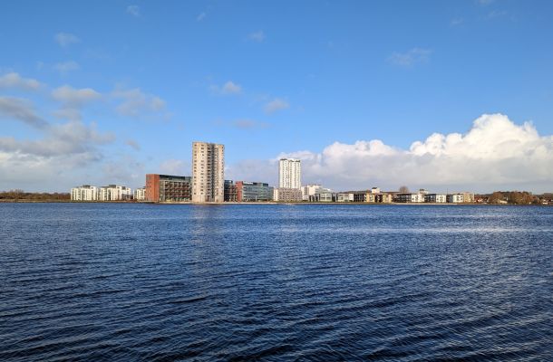 Ein großes Gewässer mit Gebäuden im Hintergrund.